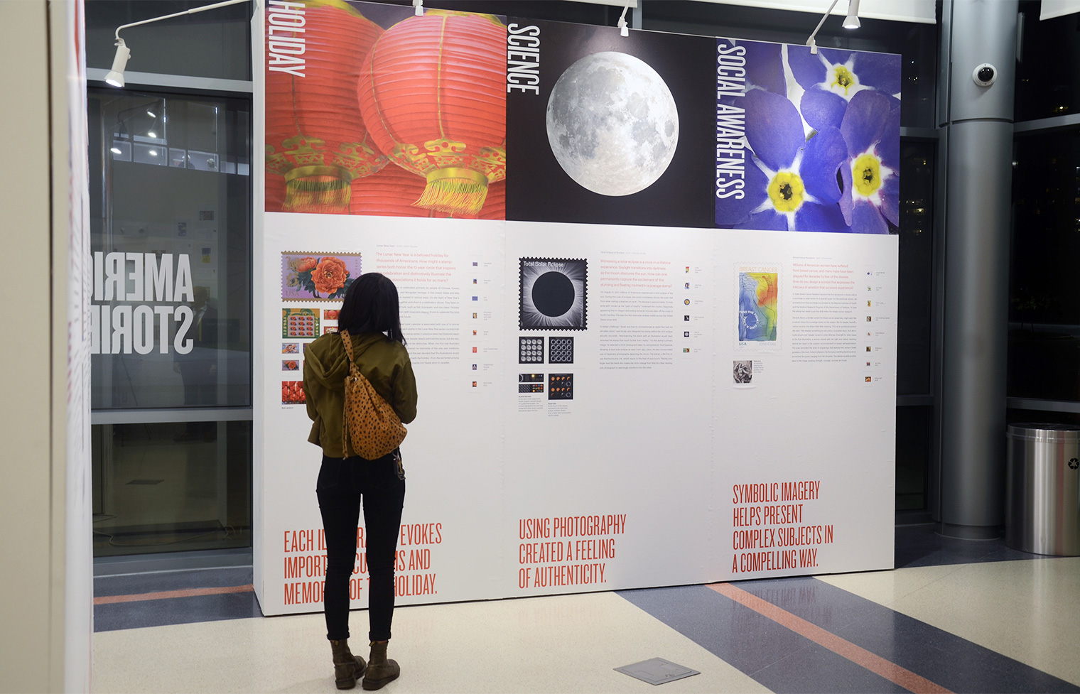 A visitor reading panels highlighting Holiday, Science, and Social Awareness with the Lunar New Year and the Total Solar Eclipse stamps.