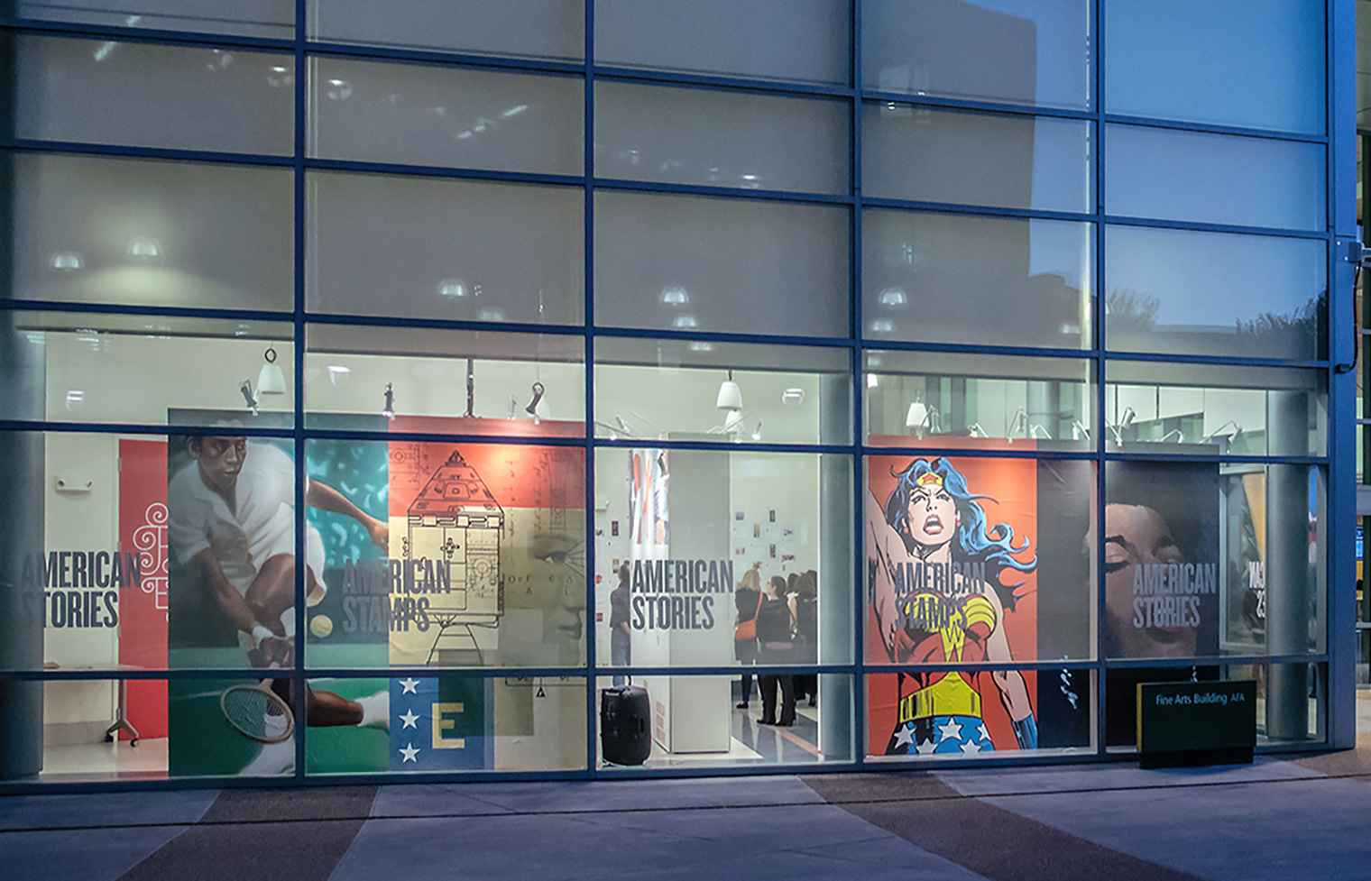 A night view of three walls feature Arthur Ashe, STEM, and Wonder Woman with vinyl title treatments applied to the windows.