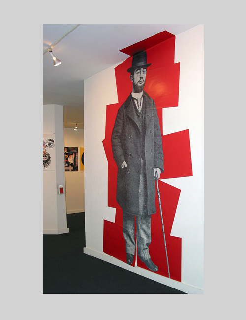Life-size wall graphic of Toulouse-Lautrec over stacked red rectangles conveys his enormous influence on graphic design.