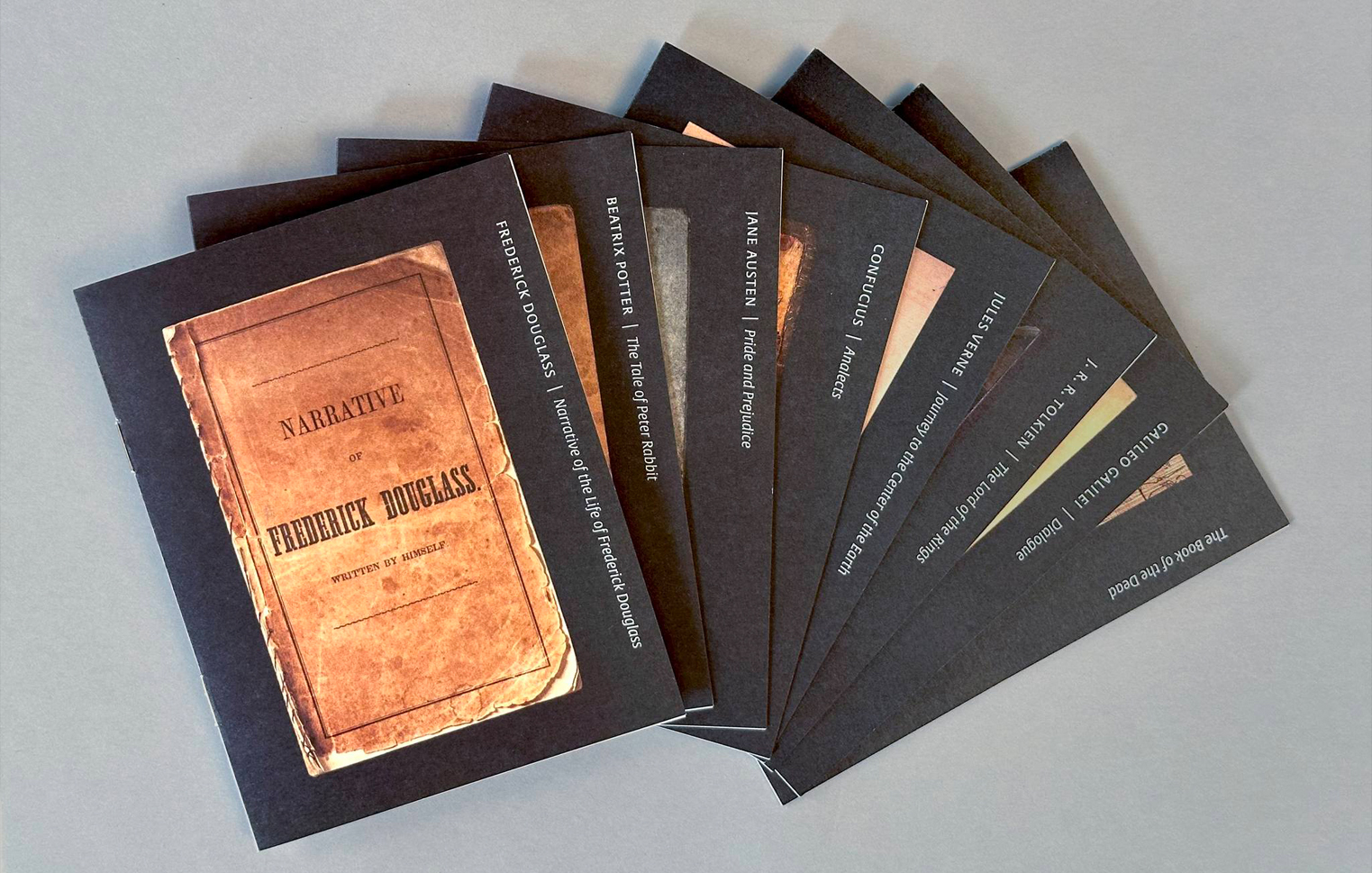 The eight giveaway booklets. Each highlights a particular book and author.